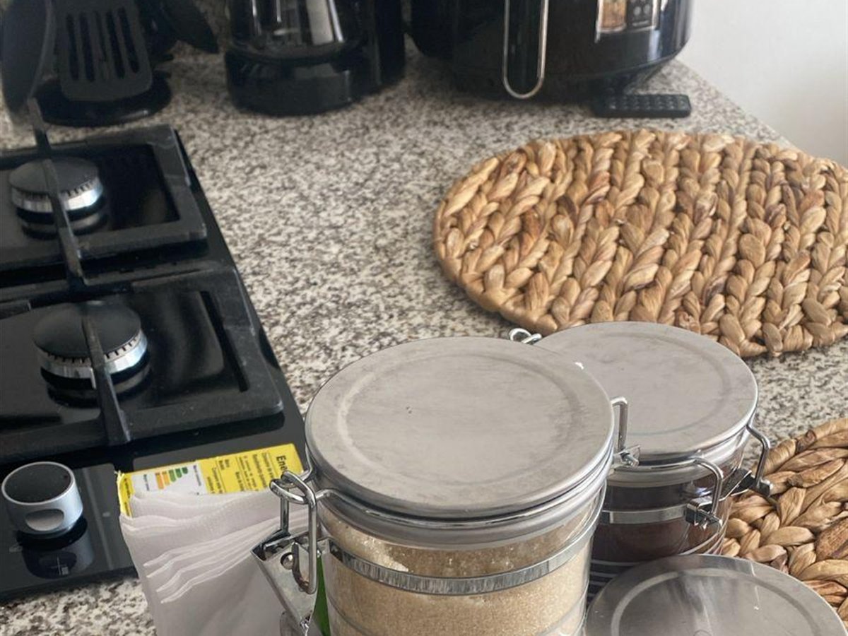 Mesón de cocina en granito con estufa a gas, cafetera y utensilios