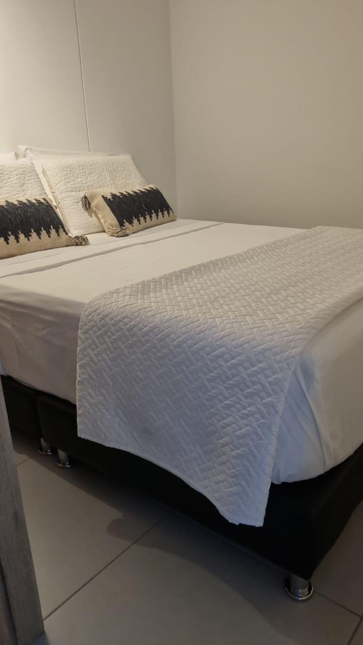 Habitación con cama doble y ropa de cama blanca