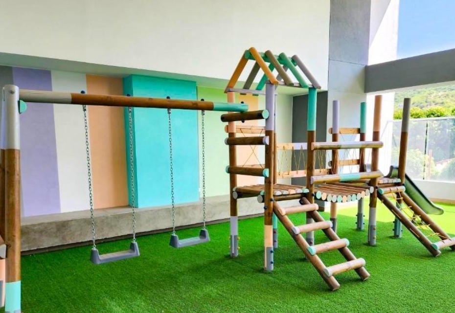 Parque infantil del edificio con grama sintética